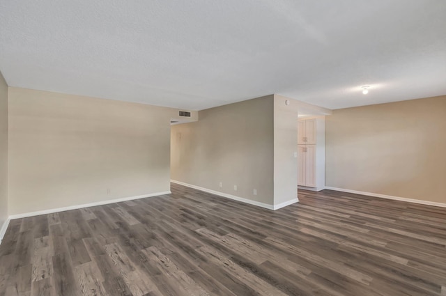 empty room featuring dark wood-type flooring and a textured ceiling