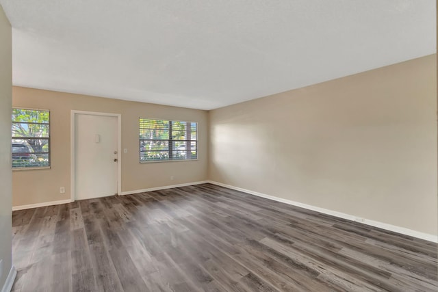 spare room with plenty of natural light and dark wood-type flooring