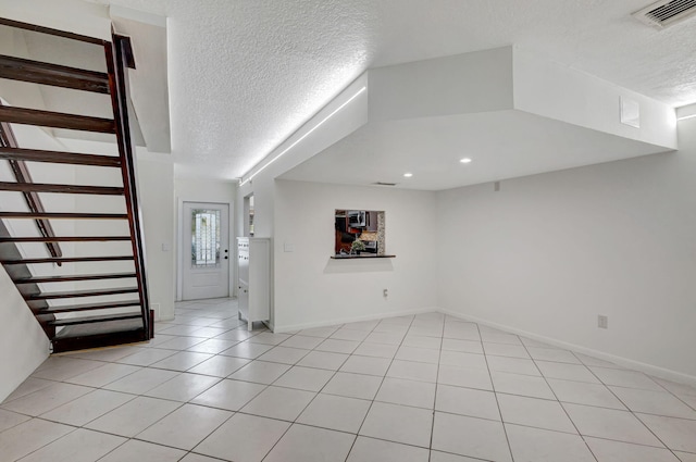 tiled entryway featuring a textured ceiling