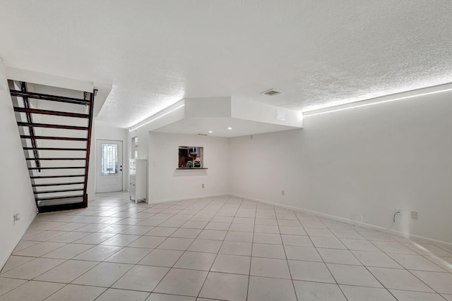 unfurnished living room featuring a textured ceiling and light tile patterned flooring