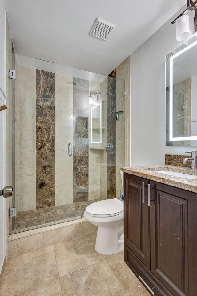 bathroom featuring vanity, toilet, and an enclosed shower