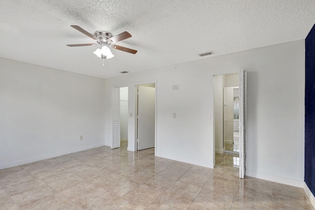 tiled spare room featuring ceiling fan and a textured ceiling