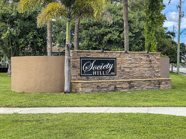 community / neighborhood sign featuring a lawn