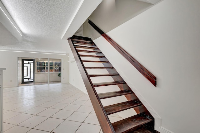 stairs featuring tile patterned floors and a textured ceiling