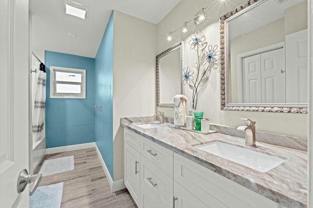 bathroom featuring vanity, hardwood / wood-style flooring, and bathing tub / shower combination