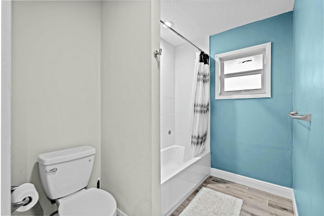 bathroom featuring toilet, hardwood / wood-style floors, a textured ceiling, and shower / tub combo with curtain