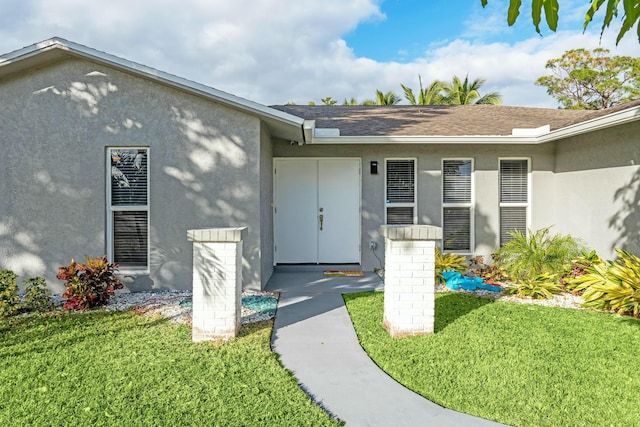 doorway to property with a lawn