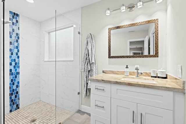 bathroom featuring a tile shower and vanity