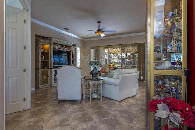 living room with a textured ceiling, ceiling fan, and ornamental molding