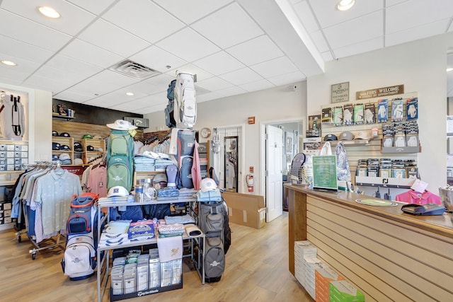 interior space featuring a drop ceiling and light hardwood / wood-style floors