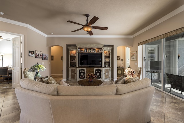 tiled living room with ceiling fan, ornamental molding, and a textured ceiling