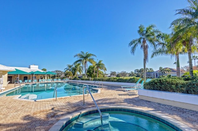 view of swimming pool with an in ground hot tub