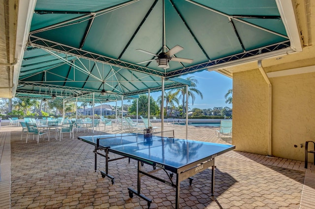 view of patio / terrace featuring a water view and ceiling fan