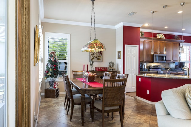 dining room featuring ornamental molding and dark tile patterned flooring