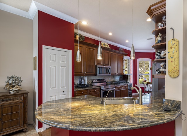 kitchen featuring appliances with stainless steel finishes, sink, pendant lighting, and dark stone counters