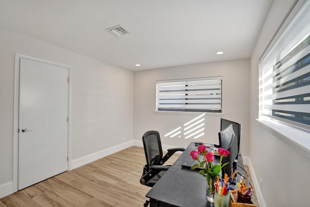 home office with light hardwood / wood-style flooring