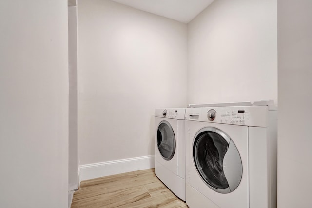 clothes washing area with light hardwood / wood-style flooring and independent washer and dryer