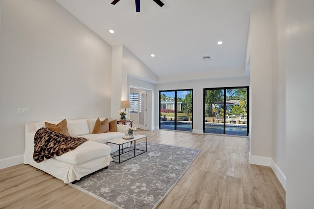 living room with ceiling fan, light hardwood / wood-style floors, and high vaulted ceiling