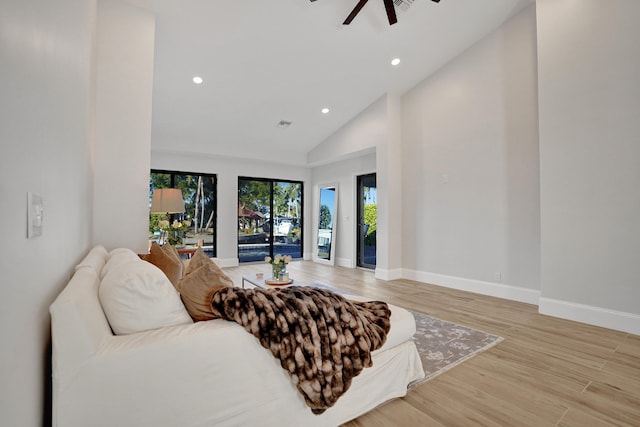 living room featuring light wood-type flooring, high vaulted ceiling, and ceiling fan