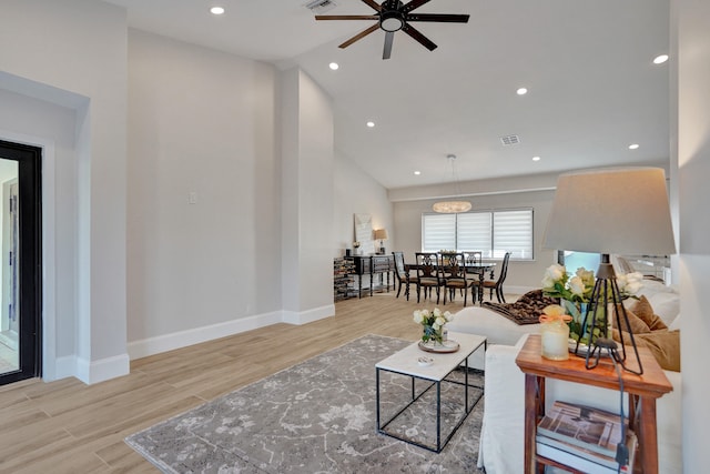 living room with light wood-type flooring, ceiling fan, and lofted ceiling