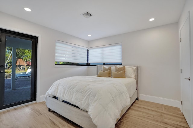 bedroom featuring access to exterior and light wood-type flooring