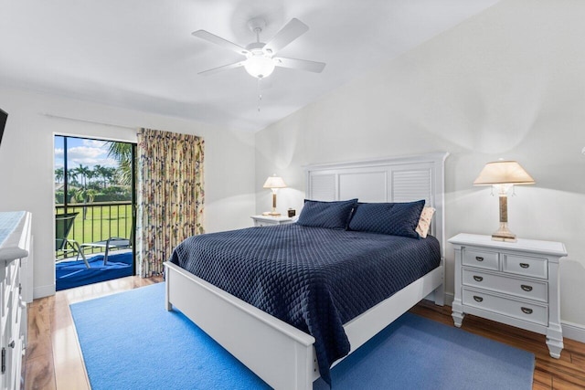 bedroom with ceiling fan, access to exterior, wood-type flooring, and vaulted ceiling