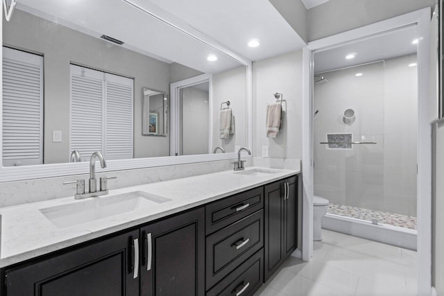 bathroom with vanity, toilet, and tiled shower