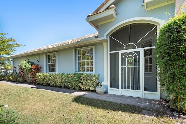 property entrance featuring a lawn