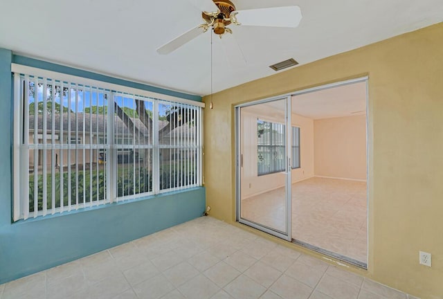 unfurnished sunroom featuring ceiling fan