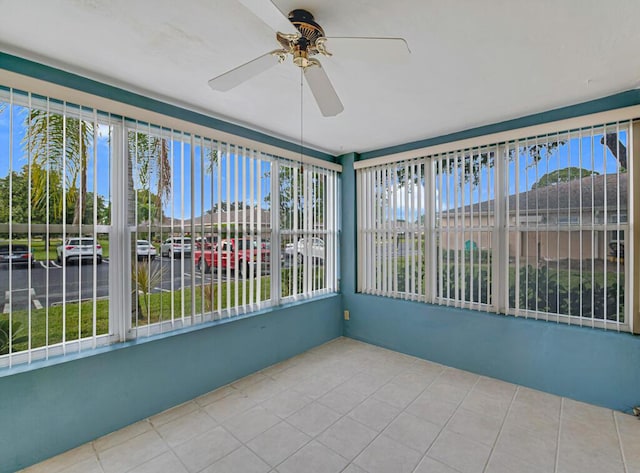 unfurnished sunroom with ceiling fan and plenty of natural light