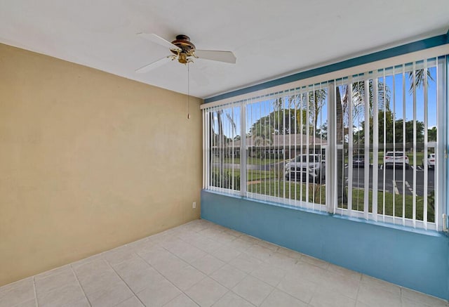 unfurnished sunroom with ceiling fan