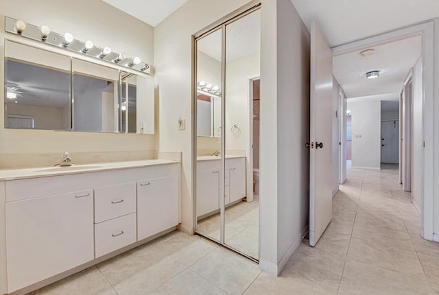 bathroom with tile patterned floors, vanity, toilet, and ceiling fan