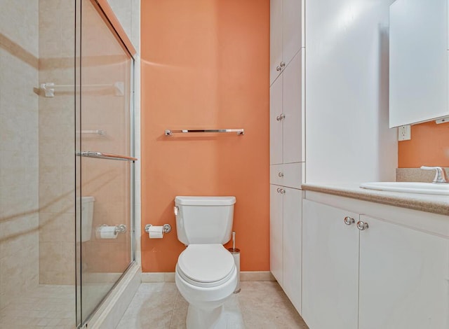 bathroom with tile patterned floors, vanity, toilet, and walk in shower