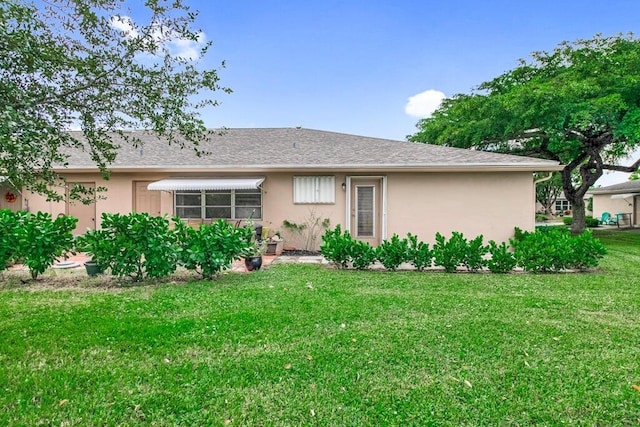 rear view of house featuring a yard