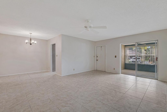 empty room with ceiling fan with notable chandelier, light tile patterned floors, and a textured ceiling