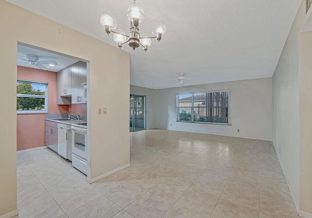 kitchen with white dishwasher, ceiling fan with notable chandelier, a healthy amount of sunlight, and range