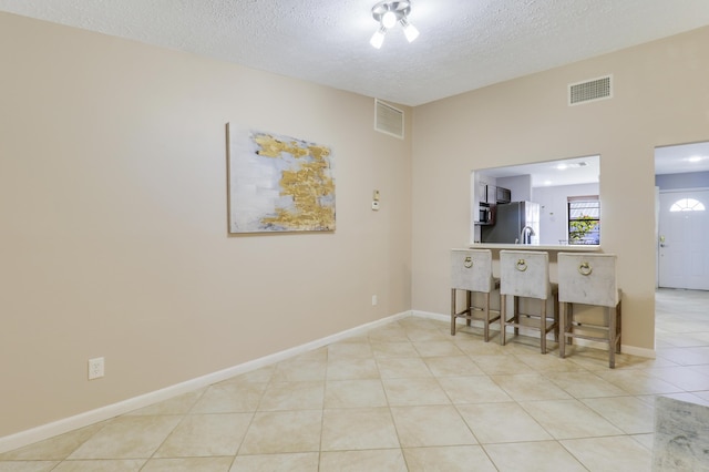 empty room featuring light tile patterned floors and a textured ceiling