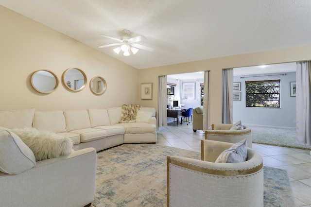 tiled living room featuring ceiling fan and lofted ceiling