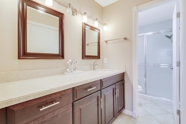 bathroom with tile patterned flooring, vanity, toilet, and walk in shower