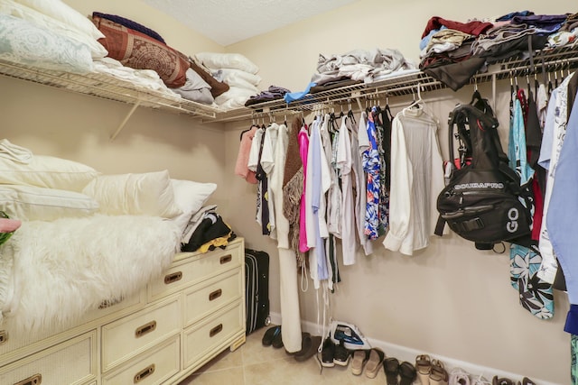 walk in closet with light tile patterned floors