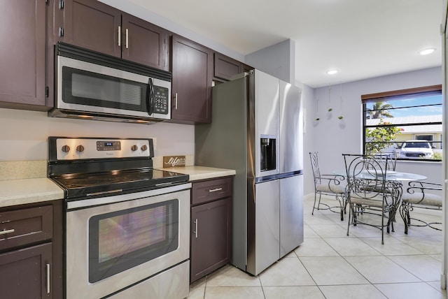 kitchen featuring dark brown cabinets, light tile patterned flooring, and stainless steel appliances