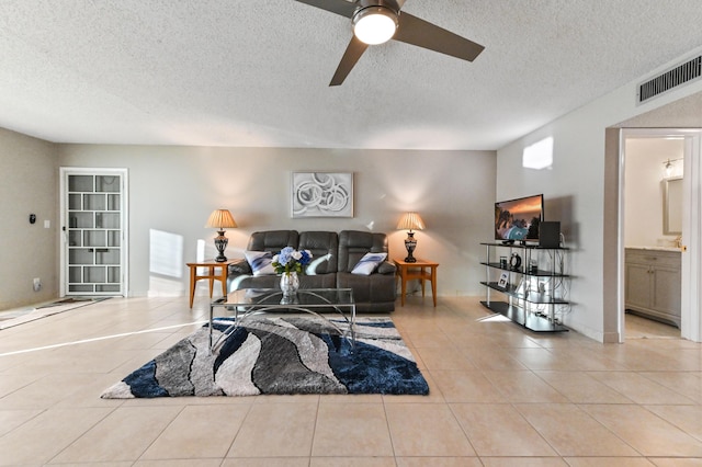 tiled living room featuring a textured ceiling and ceiling fan