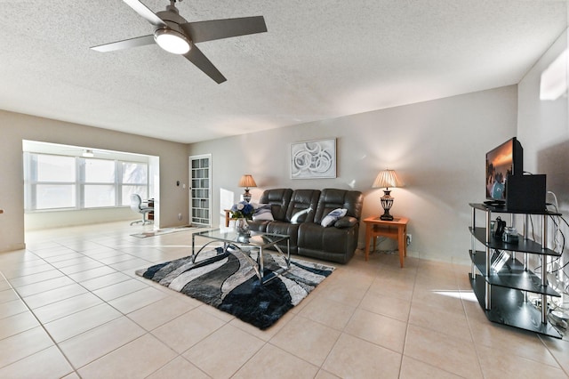 living room featuring ceiling fan, light tile patterned floors, and a textured ceiling