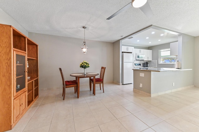 kitchen featuring white appliances, dark stone counters, kitchen peninsula, a textured ceiling, and white cabinetry