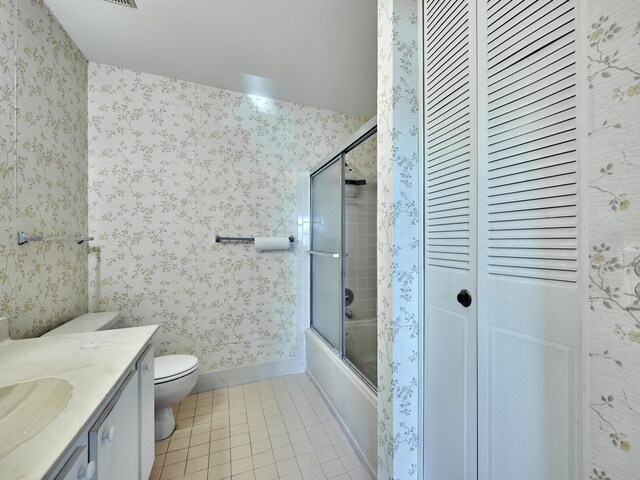 full bathroom with tile patterned flooring, vanity, enclosed tub / shower combo, and toilet