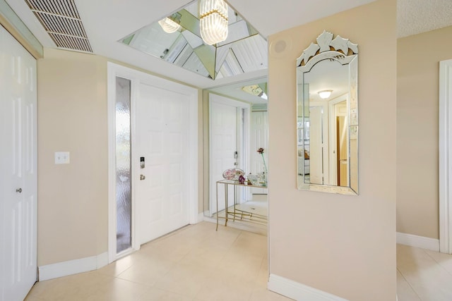 tiled foyer with a notable chandelier