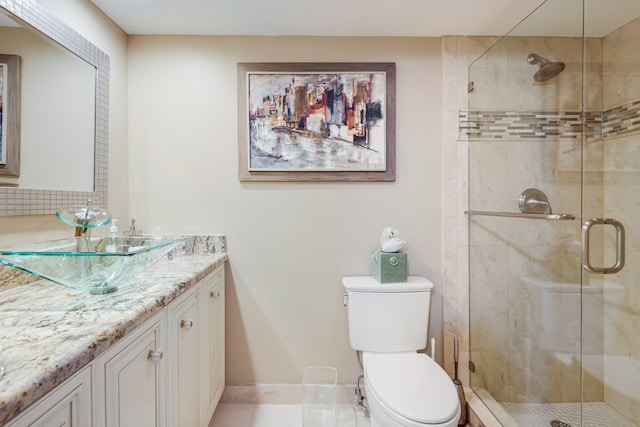 bathroom featuring a shower with door, vanity, and toilet