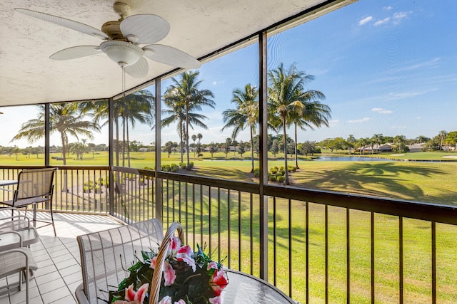 unfurnished sunroom with ceiling fan and a water view