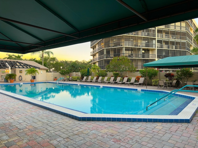 pool at dusk featuring a gazebo