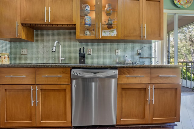 kitchen with dark stone counters, dishwasher, and sink